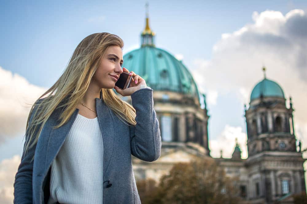 Junge Frau telefoniert vor dem Berliner Dom